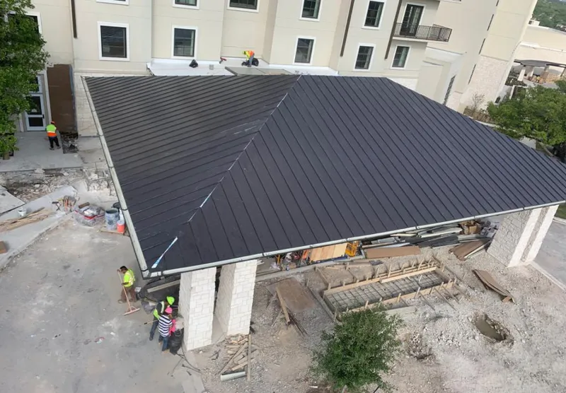 Metal roofing installation team working on a commercial building in Hampden